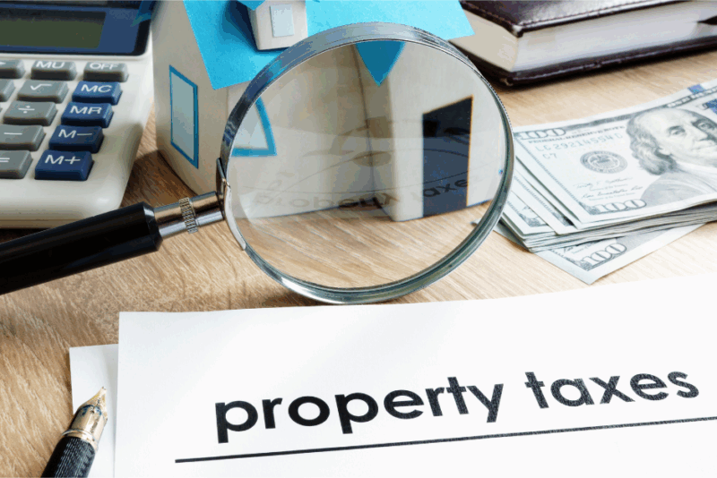 Calculator and magnifying glass used to figure out what pop-up tax will be after purchasing a condo or home