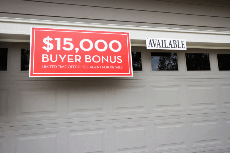 Garage door with sign offering a buyer bonus incentive on a property for sale
